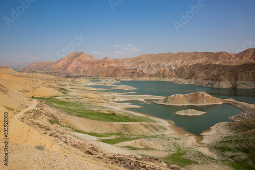 View of a mountain valley with a Azat river reservoir with a bright turquoise color in Armenia and arid terrain in the background.