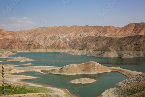 View of a mountain valley with a Azat river reservoir with a bright turquoise color in Armenia and arid terrain in the background. photo