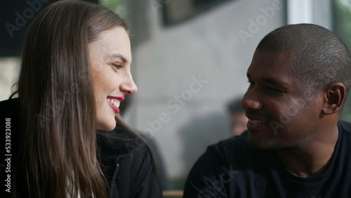 Romantic diverse couple laughing and smiling. A black man leaning on white girl shoulder showing love and affection