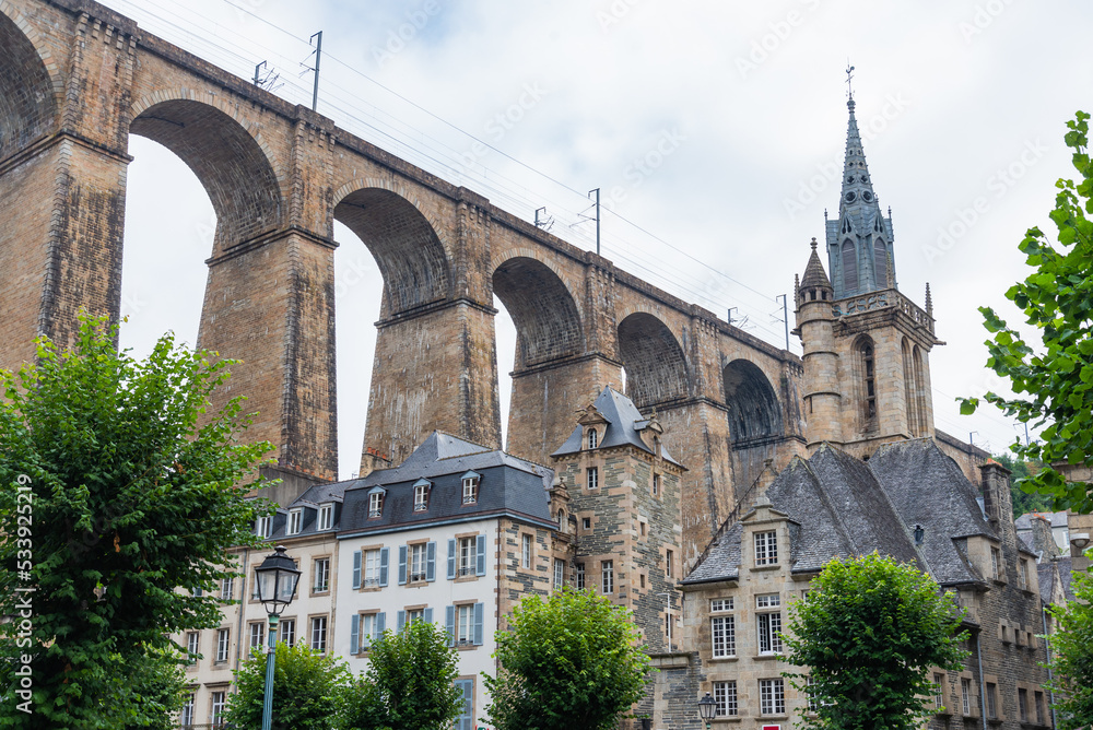 The historical centre of Morlaix, Brittany, France, with its traditional buildings. On the background the famous railway bridge, with its arcade, and the cathedral.