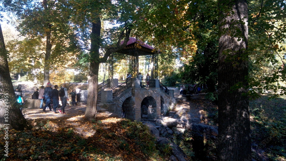 Old stone bridge in the park. Autumn trees reflected in water. Scenic golden autumn in the park. Beautiful autumn landscape in the morning. Old stone bridge in the park. Autumn trees reflected in water. Scenic golden autumn in the park. Beautiful autumn landscape in the morning.