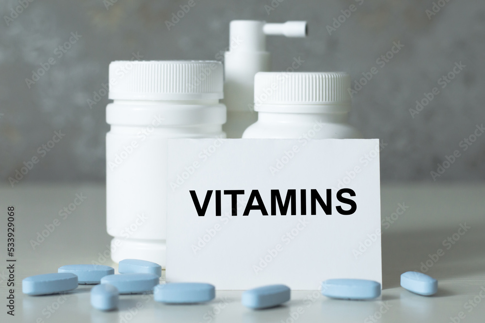 Vitamins text on card the a table, concept background Vitamins text on card the a table, concept background