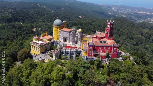 Aerial drone view of Park and National Palace of Pena in Sintra, Portugal during a sunny day. Unesco World Heritage. Historic visits. Holidays and summer vacation tourism. Colorful palace. 
 photo