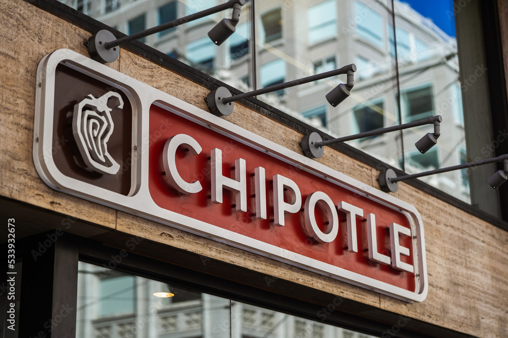 The logo sign of a Chipotle fast casual restaurants with Mexican grill