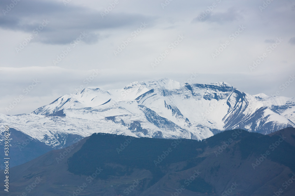 Snow-white mountain peaks. Snowy summits against the sky. Panoramic view of the Caucasian mountains in Dagestan, Russia