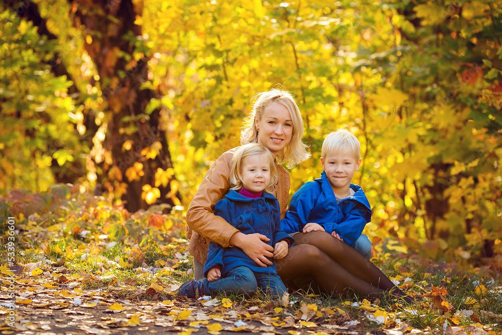 Mom and kids in autumn park, family fun. family enjoying a walk in nature. happy motherhood concept.