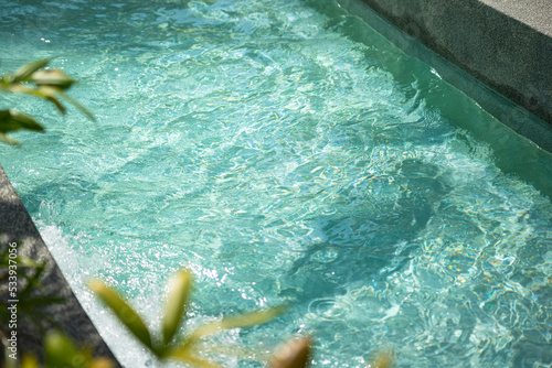 Clearly transparent turquoise water swimming pool at the water park. Recreation place for background photo. Selective focus at water surface.  photo