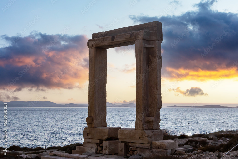 Naxos island, Greece. Sunset over Apollo Temple Cyclades Sea, cloudy sky background.