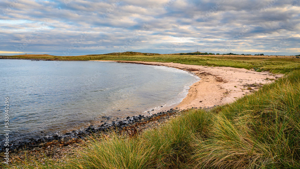 Football Hole Bay south of Snook Point, on the Northumberland coast, a designated Area of Outstanding Natural Beauty, known for its wide beaches high sand dunes punctuated by dark whinstone outcrops