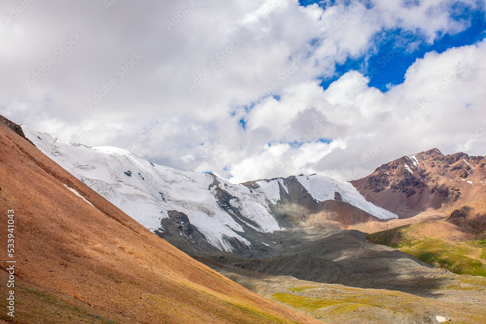 Fototapeta premium Beautiful nature of rocky mountains and peaks with glaciers. Unusual landscape of nature. Rocks on the background of the sky with clouds. Bad weather cyclone, rainy season, foggy day.