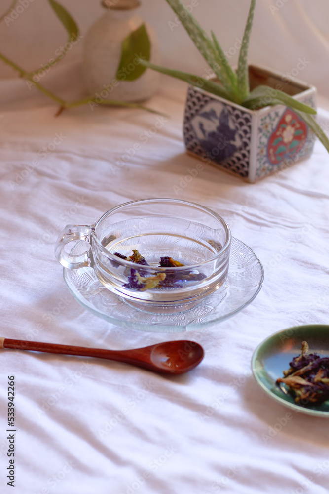Vertical shot of a cup of healthy blue butterfly pea or clitoria ternatea showing concept of wellness, wellbeing and autumn aesthetic Vertical shot of a cup of healthy blue butterfly pea or clitoria ternatea showing concept of wellness, wellbeing and autumn aesthetic