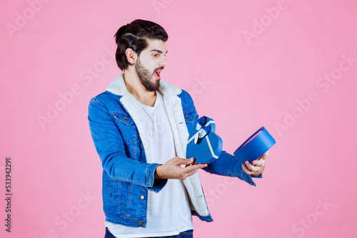 Man opening a gift box and looks surprized