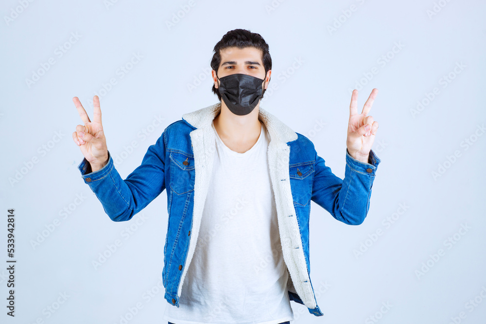 Naklejka premium Man in black mask showing enjoyment sign and feeling good