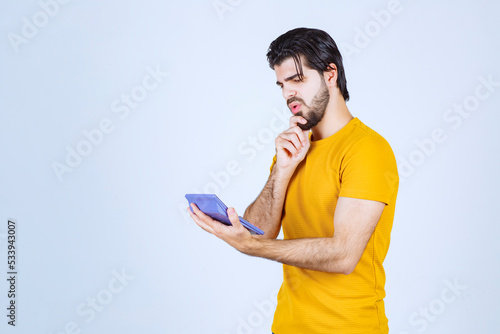 Man working with calculator and thinking photo