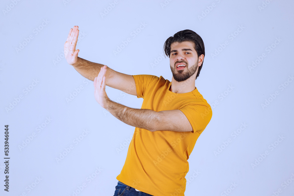 Man in yellow shirt stopping something Man in yellow shirt stopping something