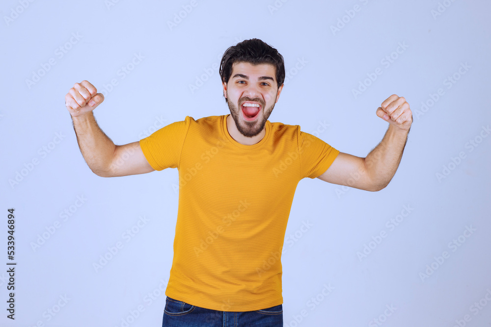 Man with beard demonstrating his fist and arm muscles and feeling powerful