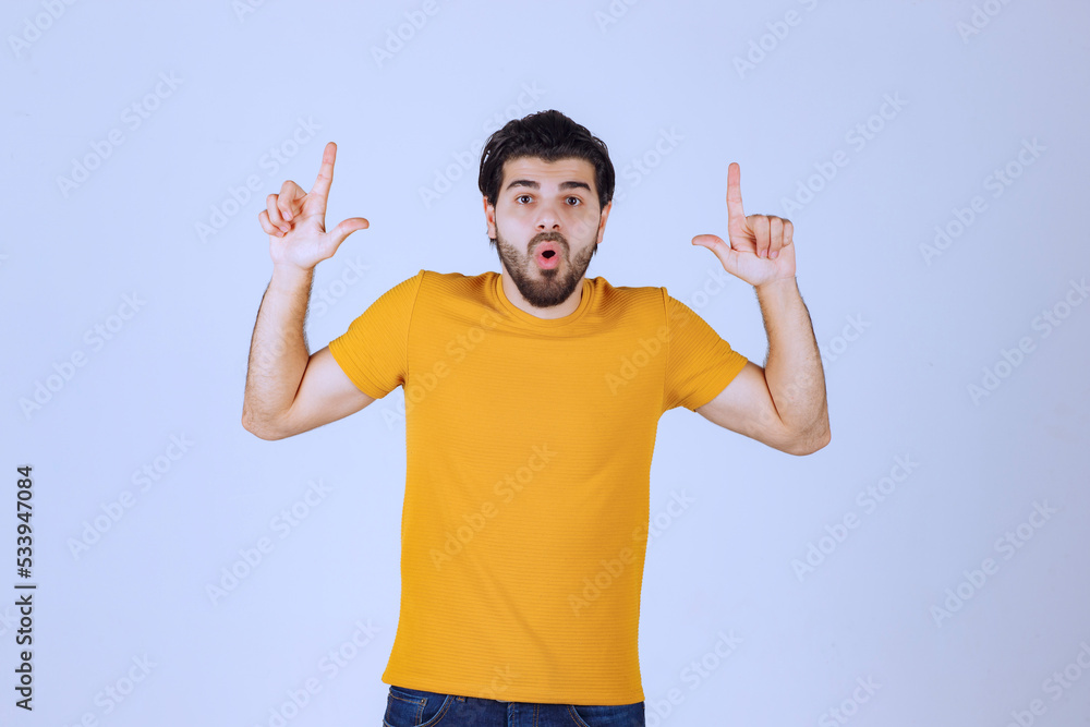 Man with beard pointing at something above Man with beard pointing at something above