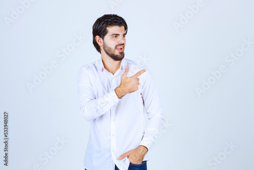 Man in white shirt pointing at something on the right