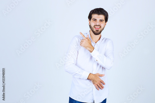 Man in white shirt pointing somewhere on the left with face emotions