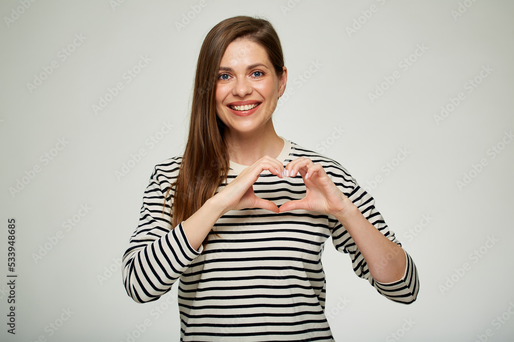 Smiling woman making heart shape with her hands. Isolated portrait. Smiling woman making heart shape with her hands. Isolated portrait.