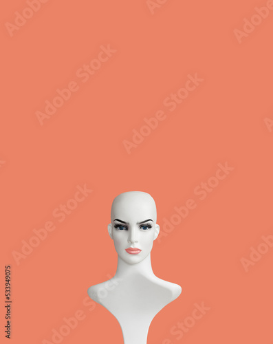 White plastic female mannequin doll portrait on powder color background