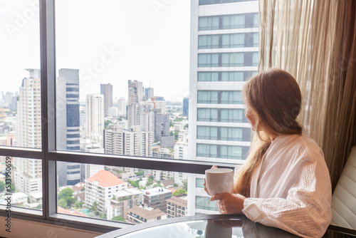 Photography Woman in bathrobe with coffee cup sitting in modern hotel or apartment