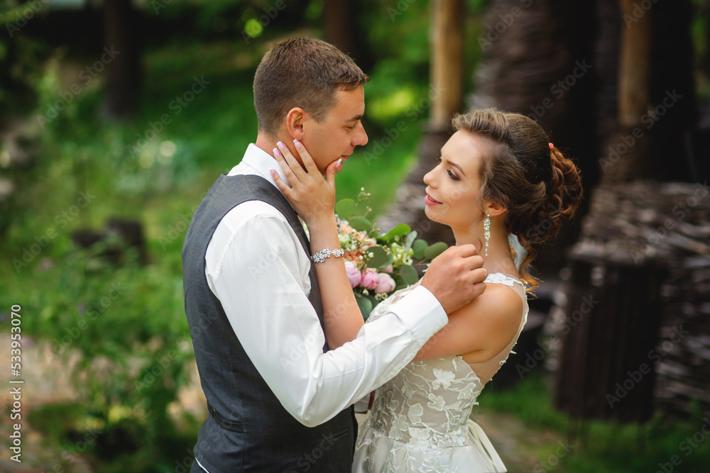 wedding couple looking at each other with love while standing in the forest