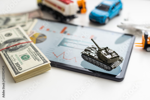 a toy tank, dollars and a tablet