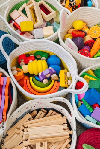 Colorful Toy Storage Baskets in the children's room. Cloth stylish Baskets with wooden toys. Organizing and Storage Ideas in nursery. Clean up toys and reduce the clutter. Top view