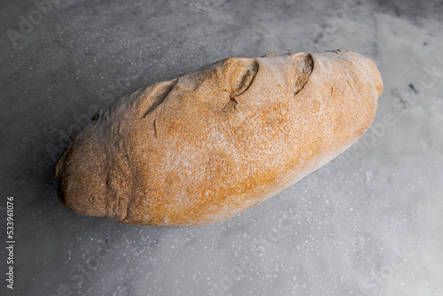 Barra de pan artesanal hecha en restaurante en estilo italiano apoyado en mesa de mármol
