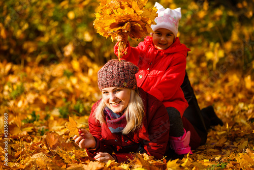 Young mother with her little daughter in an autumn park