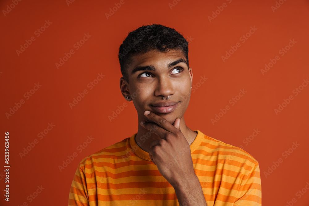 Young black man with piercing smiling and looking aside Young black man with piercing smiling and looking aside
