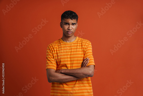 Young handsome african man with folded arms looking at camera