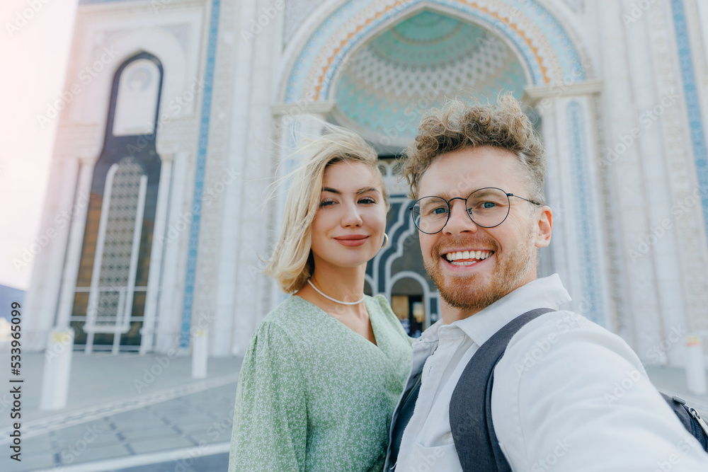 Happy tourist lover couple takes selfie photo against mosque of NurSultan Astana Kazakhstan city center