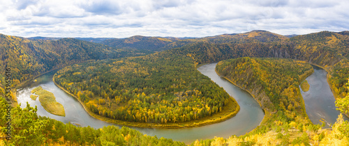 Colorful autumn panoramic landscape with loop on meandering river among mountains in Siberia. Mana is a river in Krasnoyarsk Krai, Russia, right tributary of the Yenisey. Loop on Mana river. Top view photo