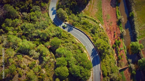 Aerial view of a beautiful hilly area with a highway. Drone view of a winding road in a mountainous area with moving cars on an asphalt road.  Cars are driving in a scenic area, top view. Portugal.
