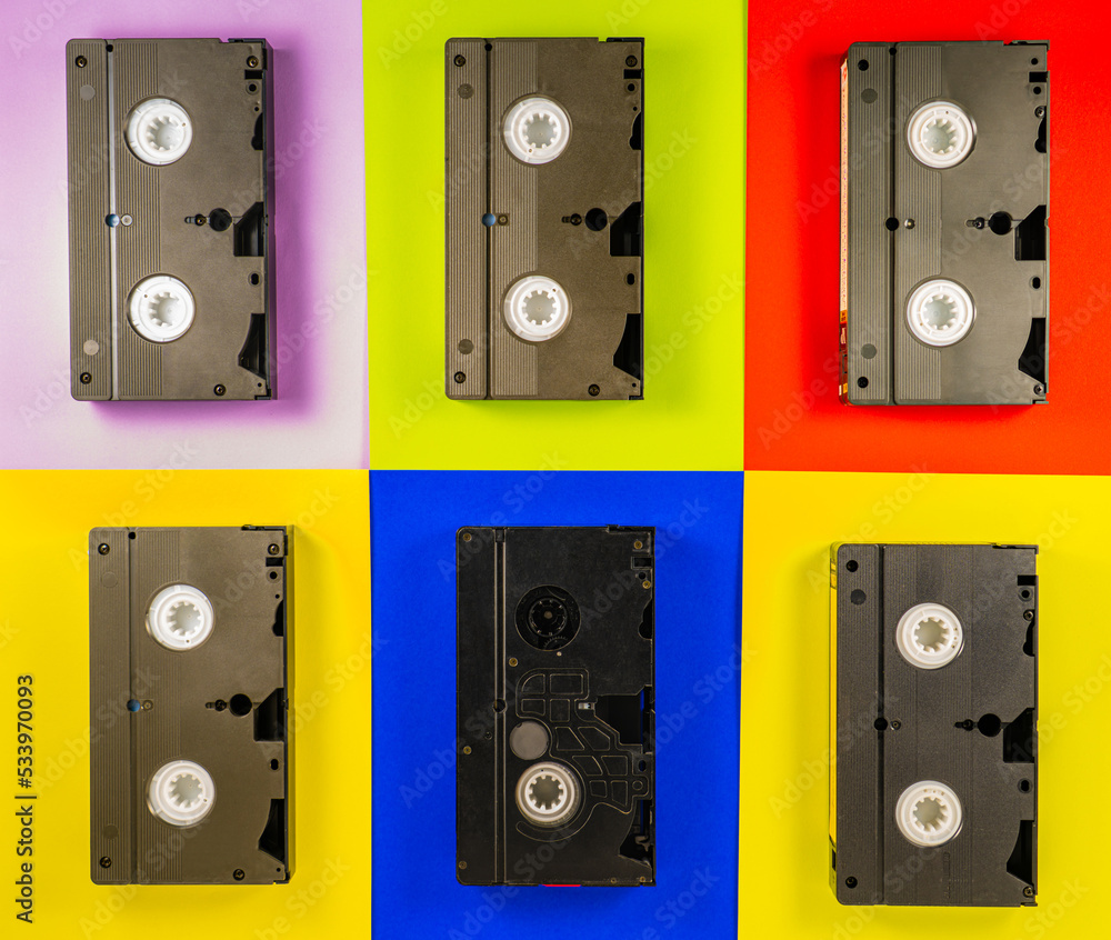 Black vintage VHS videotapes on red, blue, yellow, pink background