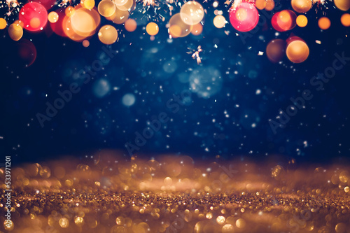 Festive golden glittering in the dark night background with blurred bokeh lights and snow. Christmas and winter holidays background photo