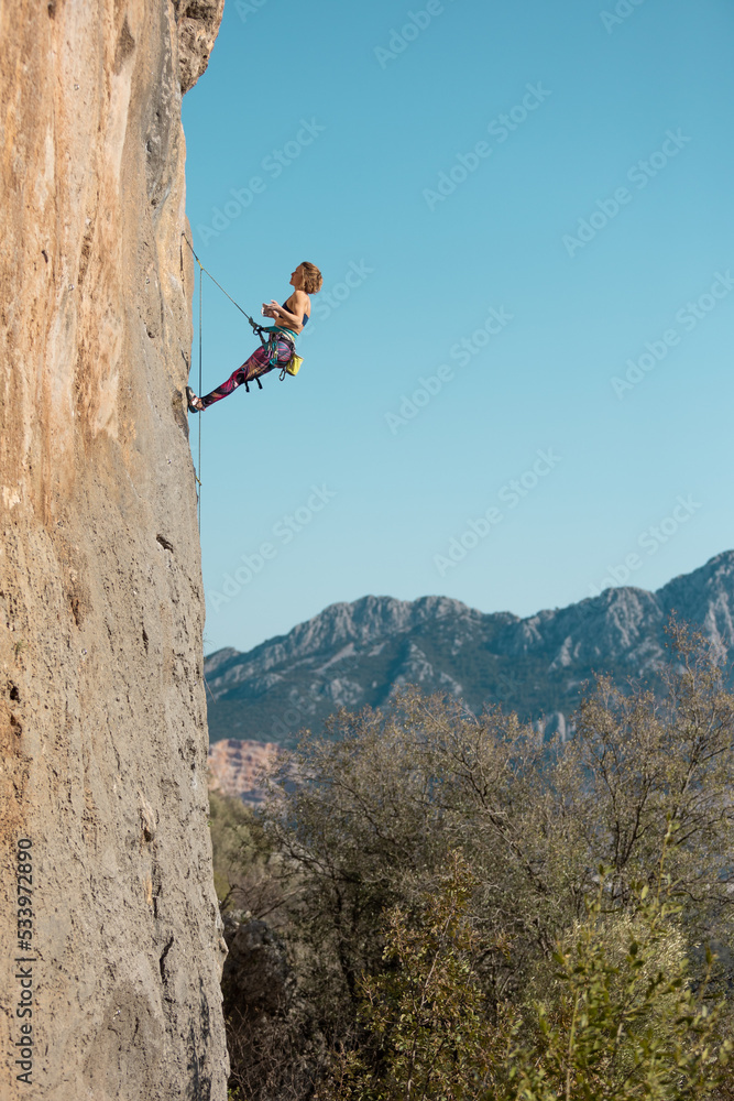 girl rock climber hanging on a rope.