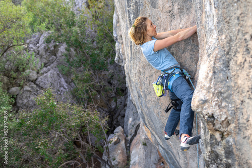 The sports girl is engaged in rock climbing