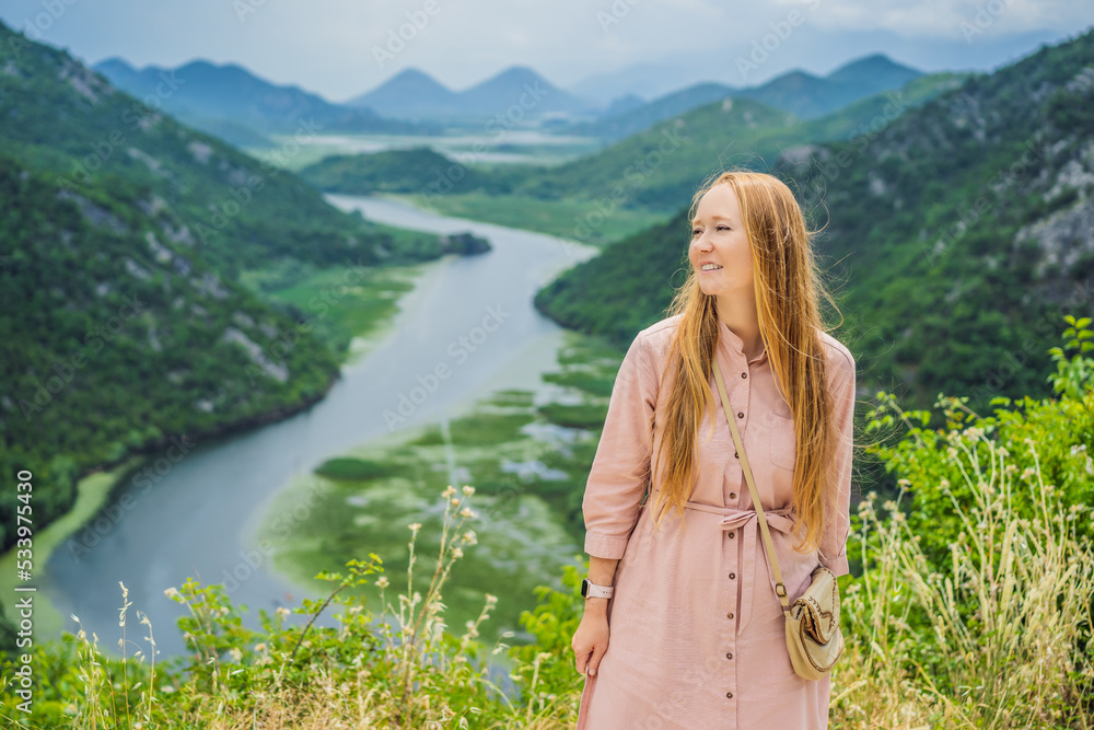 Woman tourist in the background Canyon of Rijeka Crnojevica river near the Skadar lake coast. One of the most famous views of Montenegro. River makes a turn between the mountains and flows backward