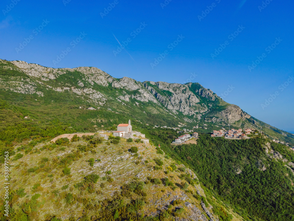 Panoramic view of the city of Budva, Montenegro. Beautiful view from the mountains to the Adriatic Sea Portrait of a disgruntled girl sitting at a cafe table