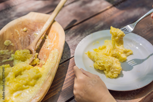 Traditional Montenegrin Meal. Kacamak in wooden bowl in the outdoor cafe