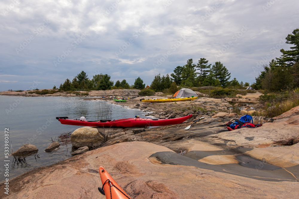 Sea kayaks and a tent on the rocky shore of Georgian Bay.  