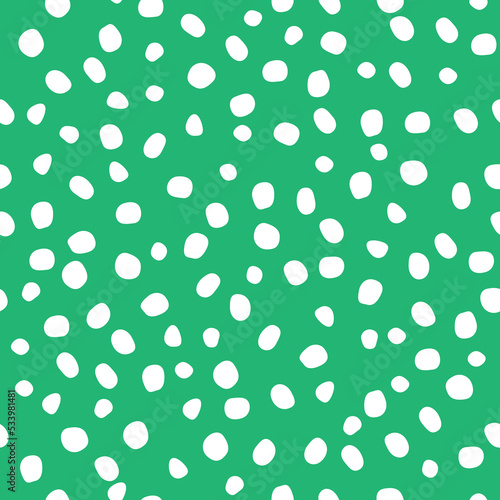 Abstract seamless pattern of hand-drawn white dots-specks on a green background. Different sizes and shapes of white spots (polka dots) on a green background -perfect seamless pattern