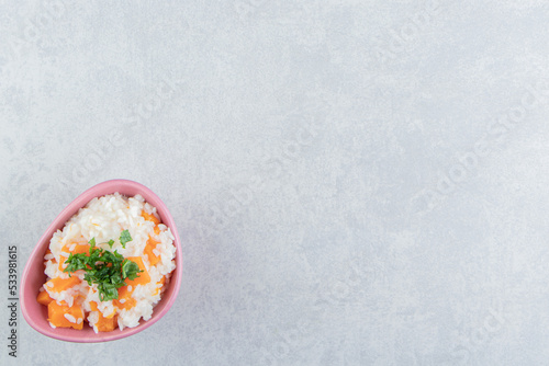 Sliced parsley and carrot rice in the bowl , on the marble background