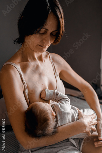 Mom, mummy, young mother with little baby daughter. Breast-feeding. Mum feeding child with breast milk.Newborn cute happy girl smiling in woman hands.Family happiness.Age parents,parenting,motherhood