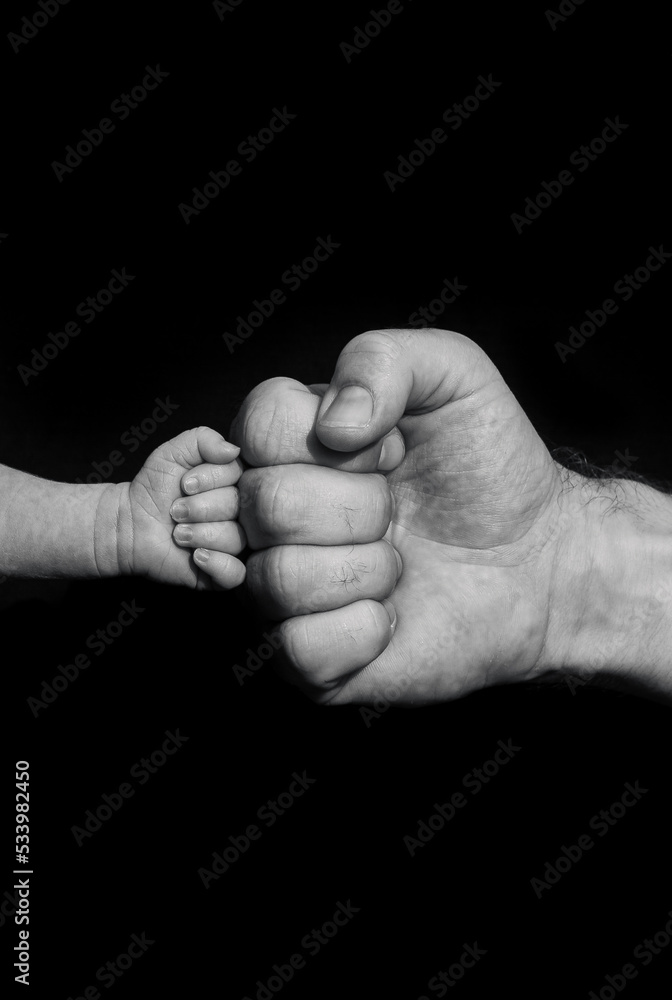 Newborn baby fistbumps with dad. Sign of power, fighting spirit or success. Newborn baby fistbumps with dad. Sign of power, fighting spirit or success.