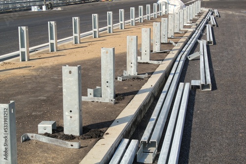 Installing a new road railing infrastructure. Steel crosspieces laying highway equipment. Construction of tracks for cars. Development and improvement of transport junction. Erection overpass in city