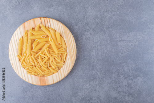 Two kinds of pasta on wooden plate